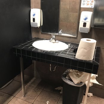 Cicis Pizza - a bathroom with a sink and toilet paper dispenser - Pizza Near Me - Topeka, Kansas