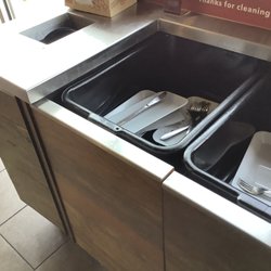 Noodles and Company - The dish disposal area had hardened waste stuck to it.