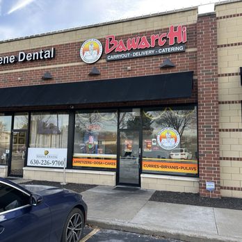 Bawarchi Express - The image shows the exterior of Bawarchi Indian Cuisine and Serene Dental, two businesses in a strip mall with brick and beige walls, large windows, and signage. - Indian Near Me - Bolingbrook, Illinois