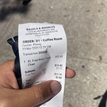 Bagels & Noodles - a hand holding a receipt - Breakfast & Brunch Near Me - Gainesville, Florida