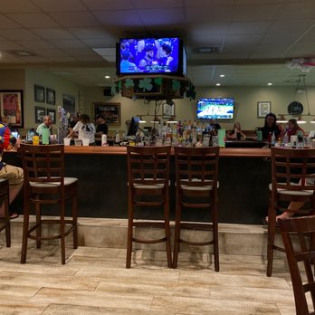 Oasis Lounge - people sitting at the bar and watching tv - Dive Bars Near Me - Melbourne Beach, Florida