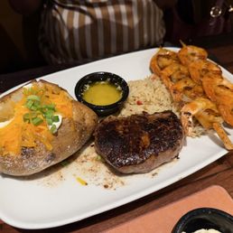 Shrimp and steak with Loaded Baked Potato and Seasoned Rice Pilaf