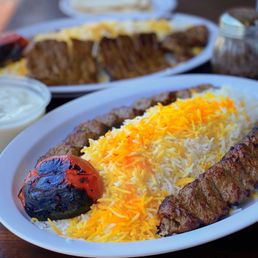 #5 Double Koobideh ($13), #9 Soltani Combo w/ filet mignon, koobideh ($26), Mast-o-moosir: Yogurt w/ shallots ($4). Three outdoor tables.