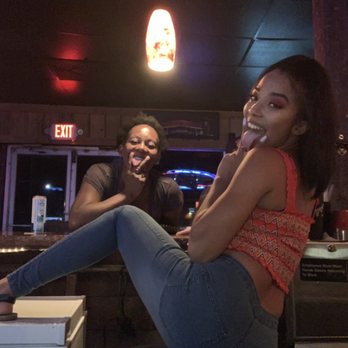 Speedway bar - a woman sitting on a stool with her legs crossed - Dive Bars Near Me - Daytona Beach, Florida