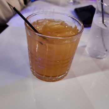 EnV - Side Car - A glass of iced tea with ice cubes and a black straw is placed on a white table in a restaurant setting. - Breakfast & Brunch Near Me - Memphis, Tennessee