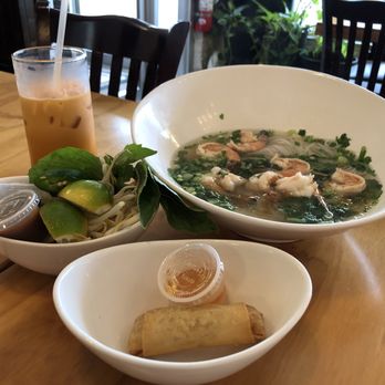 Thai Thai Villa - (R-l) Pho soup with shrimp, noodles, scallions; a spring roll with dipping sauce; bean sprouts, lime and basil; and Thai iced tea. - Thai Near Me - Huntington, New York