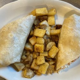 Breakfast burrito with well done egg whites, bacon, tomato,onion and cheese served with home fries Breakfast burrito with well done egg whites, bacon, tomato,onion and cheese served with home fries