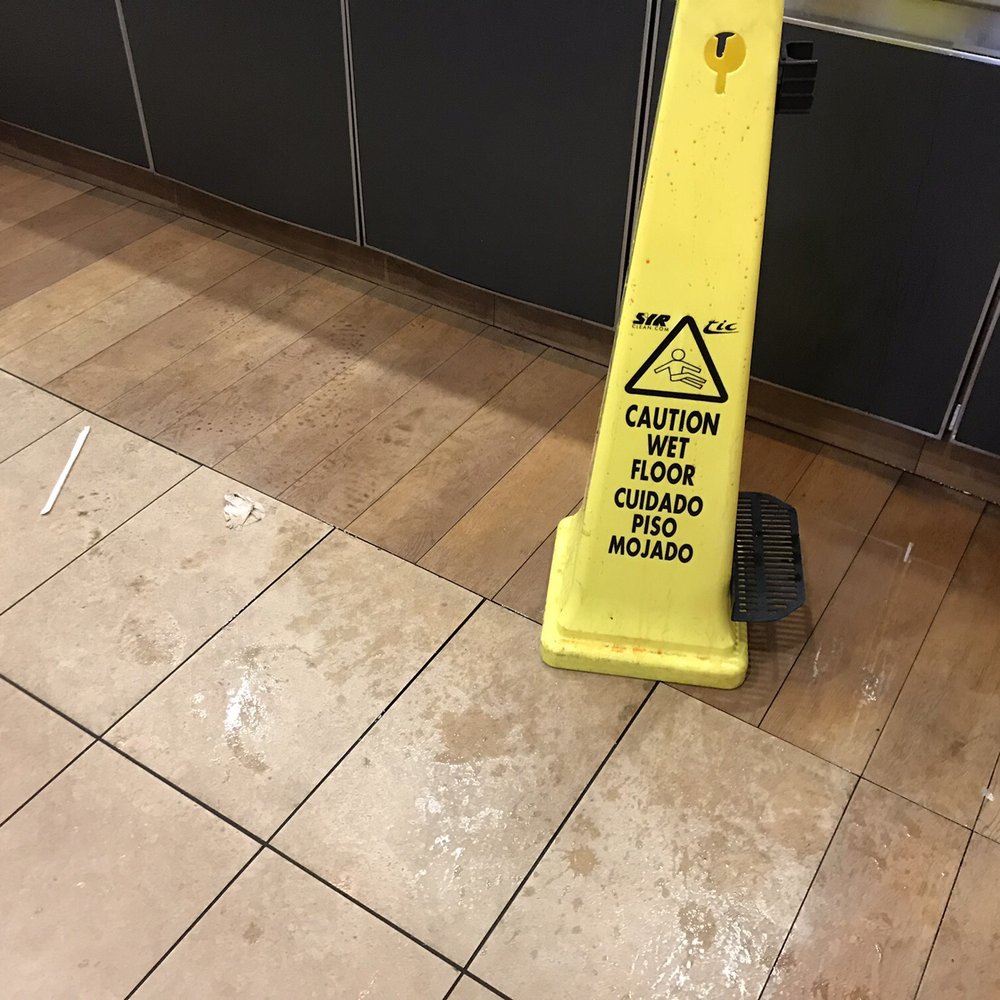 Don't clean it up. Put up a wet (and sticky) floor sign...