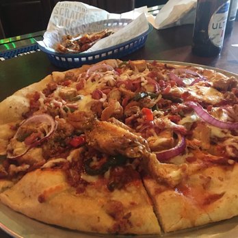 Wild Wing Cafe - Meat Pizza with one chicken wing on top from our wing basket - Chicken Wings Near Me - Gainesville, Georgia