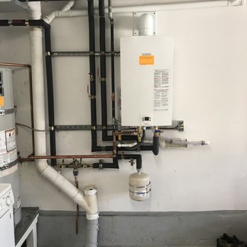 Malcolm Plumbing & Mechanical - A compact wall-mounted boiler is installed above copper piping and insulated black lines, with a small expansion tank and whi... - Plumbing Near Me - San Francisco, California Malcolm Plumbing & Mechanical - A compact wall-mounted boiler is installed above copper piping and insulated black lines, with a small expansion tank and whi... - Plumbing Near Me - San Francisco, California