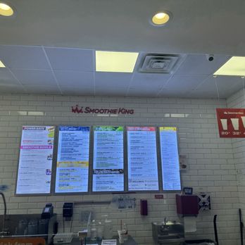 Smoothie King - Menu - Digital menu screens and store signage are visible inside Smoothie King in Yulee, FL, with a white tiled wall background. - Juice Bars & Smoothies Near Me - Yulee, Florida