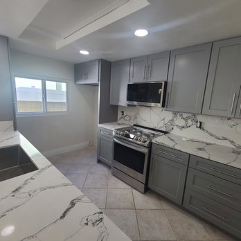 Cartage Flooring - Quartz Nile Calacatta on the Fireplace, Toletto On the Counter-top, Gray Shaker Cabinets. - Countertop Installation Near Me - Fullerton, California Cartage Flooring - Quartz Nile Calacatta on the Fireplace, Toletto On the Counter-top, Gray Shaker Cabinets. - Countertop Installation Near Me - Fullerton, California