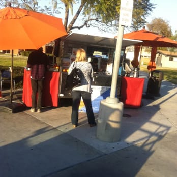 Orange Coast Doggs - a woman standing in front of a booth - Hot Dogs Near Me - Costa Mesa, California Orange Coast Doggs - a woman standing in front of a booth - Hot Dogs Near Me - Costa Mesa, California