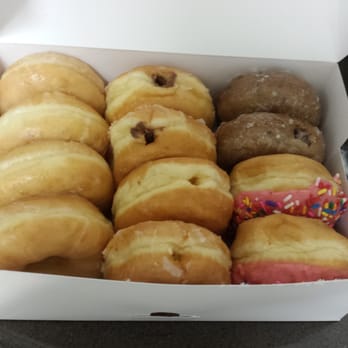 Donut Hole - Pictured here is their original glazed, chocolate filled,  Bavarian cream filled and glazed blueberry cake donuts. - Donuts Near Me - Santa Fe, Texas
