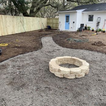 Clark Landscapes - a backyard with a fire pit - Landscaping Near Me