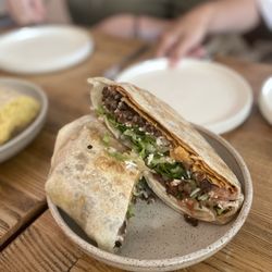 Asada Crunchwrap: tostada, refried beans, asada, daiya™ cheese, pico de gallo, cashew crema in a flour tortilla. salsa of your choice