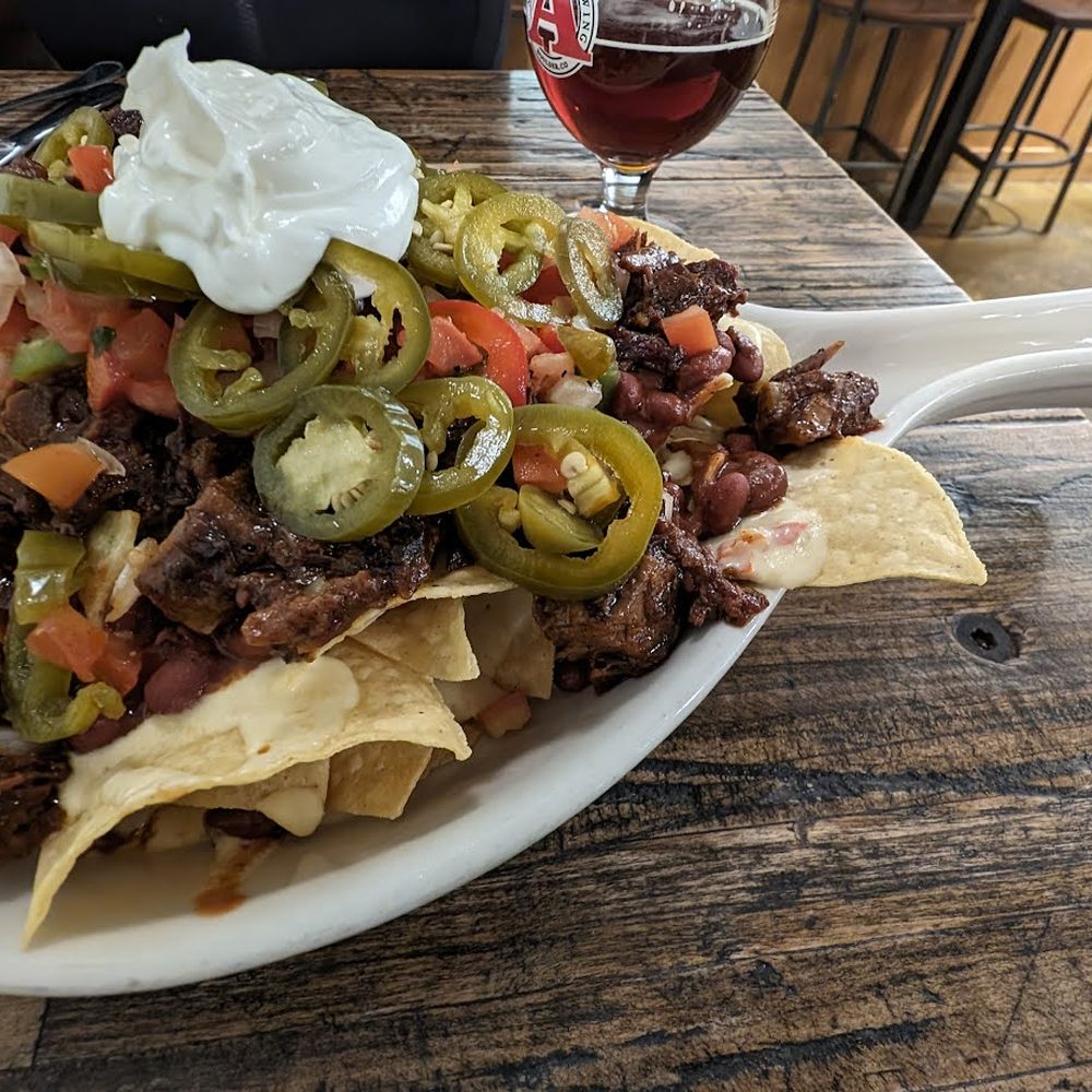 Avery Brewing - BRISKET NACHOS -  smoked brisket, red beans, nacho cheese, pickled jalapeño, crema, pico - Breweries Near Me - Boulder, Colorado