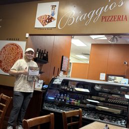 Harrison, the manager of Biaggio's Pizzeria, with their new menu.