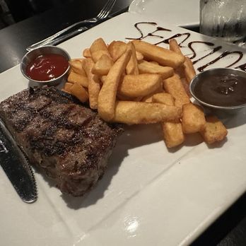 Seaside Bistro - New York strip steak with fries and Demi-glacé on the side - Steakhouses Near Me - San Pedro , California Seaside Bistro - New York strip steak with fries and Demi-glacé on the side - Steakhouses Near Me - San Pedro , California