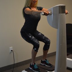Active Body Sculpt - A client using the vibration plates after her 20 minute light therapy treatment. 16 paddles are used to treat multiple parts of your body.