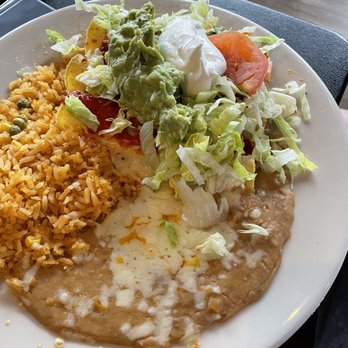 Los Cantaros - A plate featuring Mexican cuisine includes rice, refried beans, and a salad with lettuce, tomato, guacamole, and sour cream. - Mexican Near Me - Hampton, New Hampshire