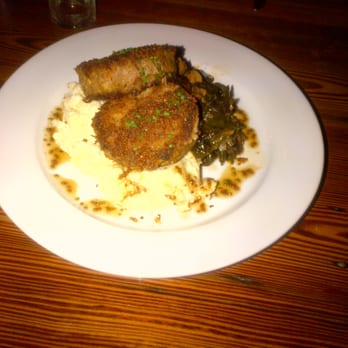 Sylvain - Pan-fried Pork Shoulder w/Coosa valley grits, braised greens, and mustard jus - Southern Near Me - New Orleans, Louisiana