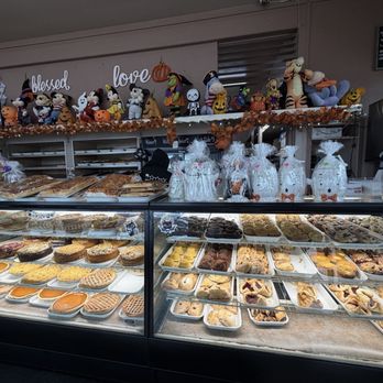Mazzetti's Bakery - Interior - A bakery display case showcases a variety of cookies, pies, and pastries at Mazzetti's Bakery in Pacifica, CA, with Halloween-themed decorations and plush toys on top. - Bakeries Near Me - Pacifica, California