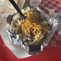A baked potato with brisket. Not enough butter or sour crème provided. A baked potato with brisket. Not enough butter or sour crème provided.
