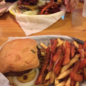 Phil's Icehouse - Chili burger with regular fries / sweet potato fries in foreground. Bacon burger with sweet potato fries in background. - Burgers Near Me - Austin, Texas