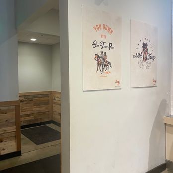 Fishers Test Kitchen - Two posters with humorous phrases and illustrations are displayed on a white wall in a dining area, with a wooden-paneled corner and a doorway visible. - Food Court Near Me - Fishers, Indiana