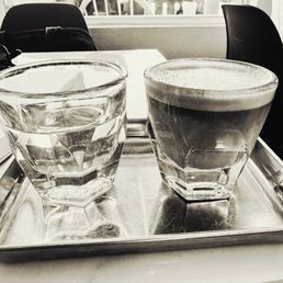 Oat milk cortado with a complimentary sparkling water!