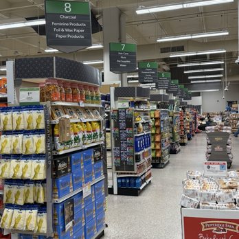 Publix - Aisles - Interior view of a grocery store with multiple aisles and overhead signs indicating sections such as Charcoal, Hair Care, Diapers, and more. Shelves are stocked with various products, and the store has bright lighting and a clean, organized layout. - Grocery Near Me - Miami, Florida