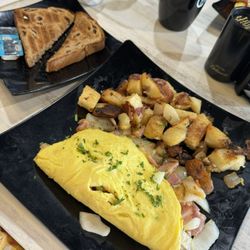 Eggtown Sarasota - Lazy Omelette ingredients just tossed in the middle of overcooked eggs. One slice of super dry cinnamon raisin toast.