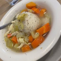a bowl of soup with dumplings and carrots a bowl of soup with dumplings and carrots