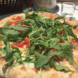 Mozzarella tomato and arugula pizza. Mozzarella tomato and arugula pizza.