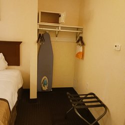 Area with room safe, ironing board and place to hang clothes.