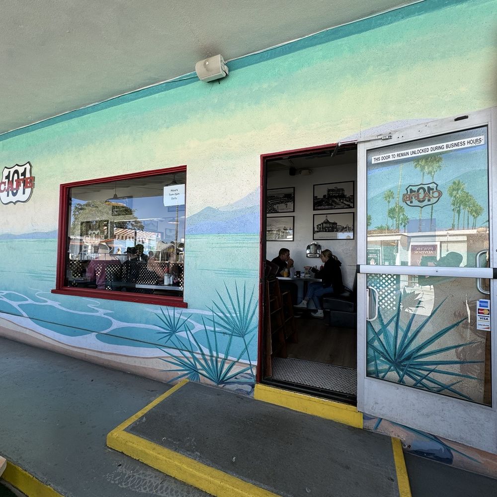101 Cafe - a woman sitting on a bench in front of a cafe - American Near Me - Oceanside, California