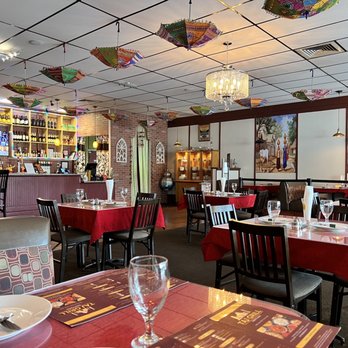 Taj Grill - tables with red tablecloths and umbrellas hanging from the ceiling - Indian Near Me - Vallejo, California