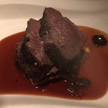 Canoe - Kangaroo lion appetizer with peppercorn crust served over a grit cake with a sweet onion balsamic sauce. Tender meat, not at all gamey. - New American Near Me - Atlanta, Georgia