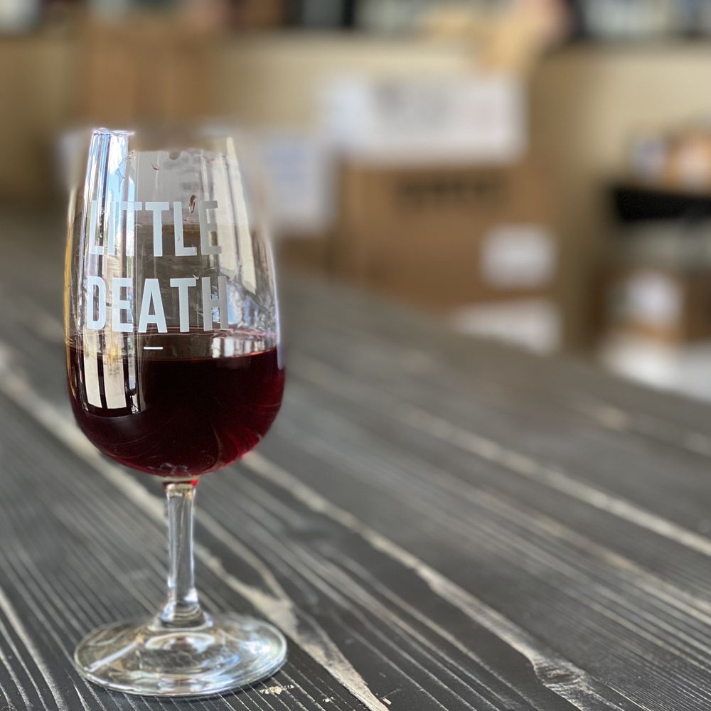 a glass of wine on a table a glass of wine on a table
