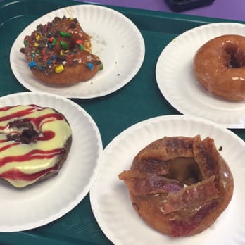 Amazing Glazed - m&ms on a glazed donut.. Bottom left is a blueberry donut with lemon icing and raspberry drizzle and beside that is maple bacon - Donuts Near Me - Chesapeake, Virginia Amazing Glazed - m&ms on a glazed donut.. Bottom left is a blueberry donut with lemon icing and raspberry drizzle and beside that is maple bacon - Donuts Near Me - Chesapeake, Virginia