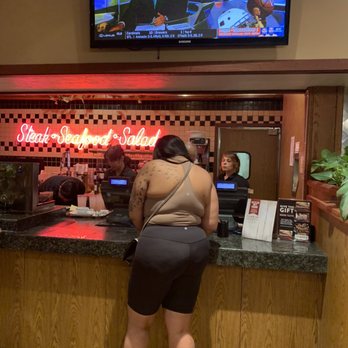 Sizzler - a woman standing at a counter in a restaurant - Seafood Near Me - Fullerton, California Sizzler - a woman standing at a counter in a restaurant - Seafood Near Me - Fullerton, California