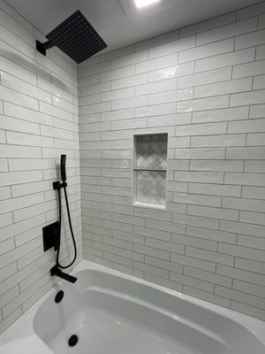Modern Makeover on this Jack and Jill bathroom - This Bathroom was a full remodel with a 25 year warranty on all tile work! I love how this bathroom came together. All new furnishings, plumbing including oversized tub, electrical, drywall work, and a huge wall to wall vanity. “Textured”subway tile Shower is complete with a 2 tier niche and stone accent. Floor tile is perfectly flat and level.