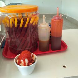 Sley 2 - Here is a mini sundae with the sauce and tamarind candy stick behind. PS He offers 3 diff flavors in the small sundae and 5 in the large