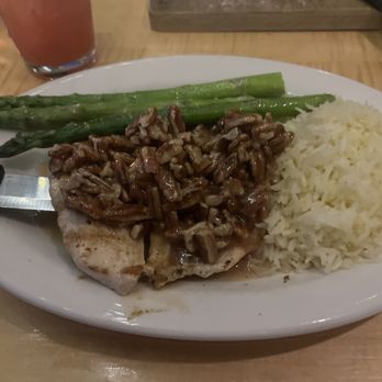 Sunset Grill - Honey pecan chicken - A meal featuring honey pecan chicken topped with chopped pecans, served with white rice and cooked asparagus on a white plate. - Steakhouses Near Me - Moab, Utah