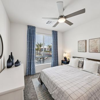 Fora - A bedroom with a large bed and a ceiling fan. - Apartments Near Me - Las Vegas, Nevada Fora - A bedroom with a large bed and a ceiling fan. - Apartments Near Me - Las Vegas, Nevada