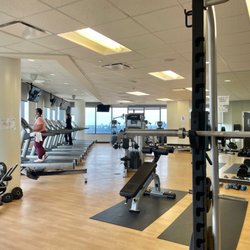 Houston Methodist Employee Fitness Center - Large room with cardio equipment (facing the windows) as well as weight machines + free weights