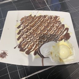 Crepe drizzled in 3 kinds of chocolate and scoop of vanilla ice cream Crepe drizzled in 3 kinds of chocolate and scoop of vanilla ice cream