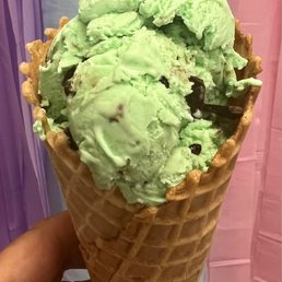 a hand holding a cone of ice cream a hand holding a cone of ice cream