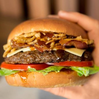Carl's Jr - a hand holding a hamburger - Fast Food Near Me - Edmonton, Alberta